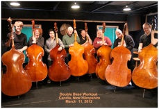 A row of double bassists with their basses at the Double Bass Workout