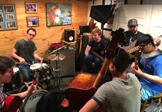 Students playing bass and drums together in Studio B