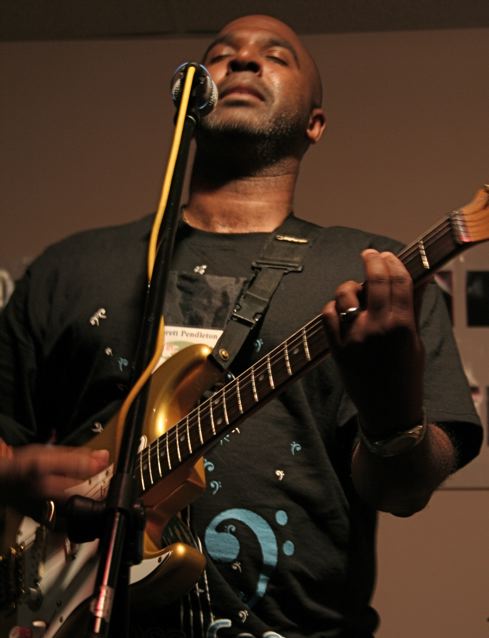Close-up of a bassist playing a fretless bass