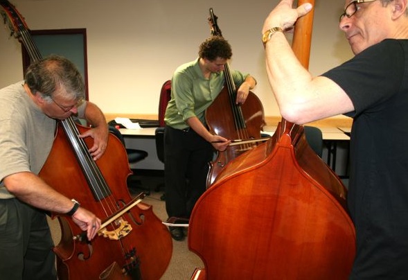 Double bassists working on bowing